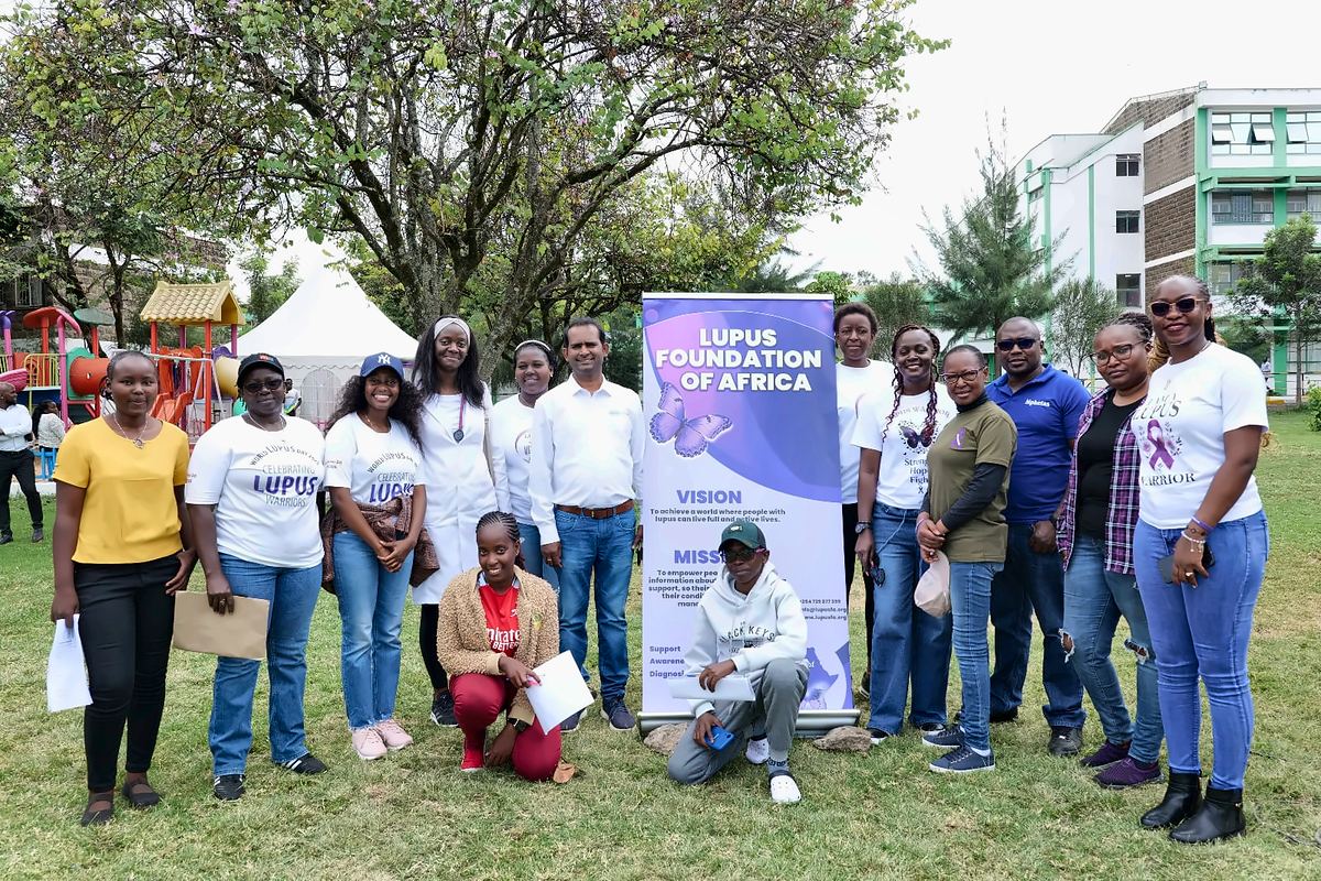 The LFA community with health workers and partners beside the Lupus Foundation of Africa banner at the Lupus Wellness & Rheumatology Camp 2025