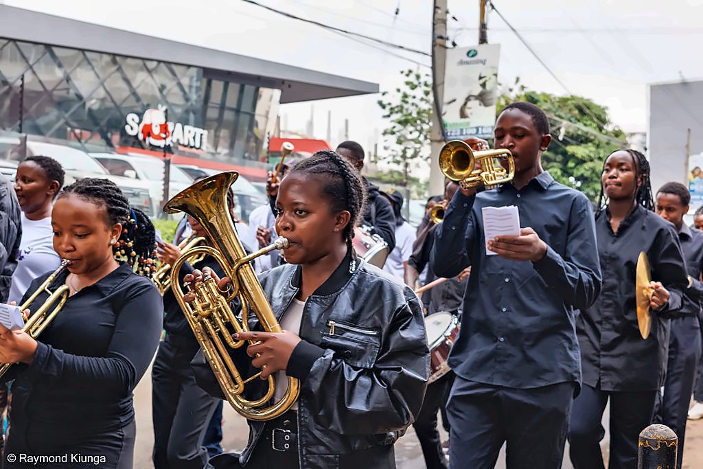 Young musicians in the brass band playing on the walk route