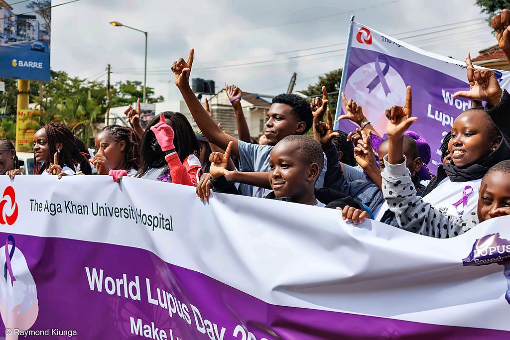The LFA community raising their hands behind the World Lupus Day 2026 banner in Nairobi