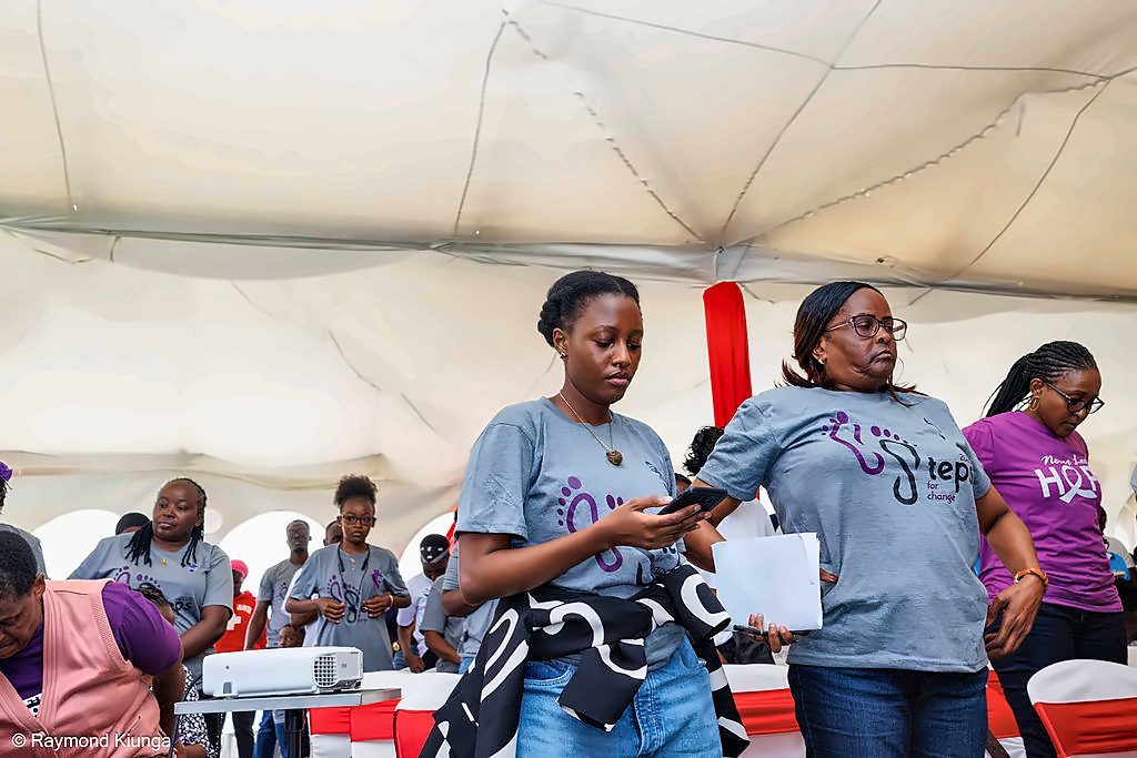 Members moving through the tent with papers and phones in hand