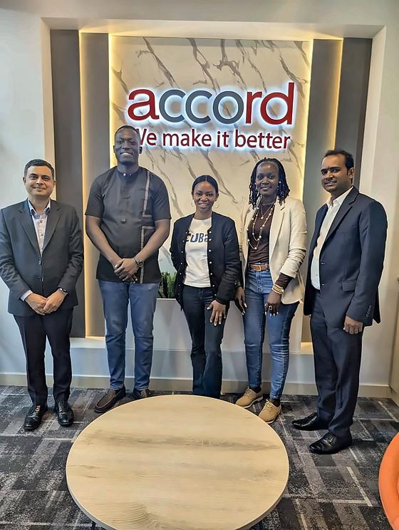 A meeting at Accord's offices, in front of the sign We make it better