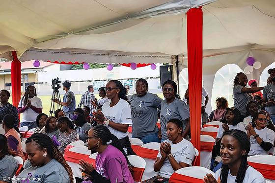 The audience laughing and applauding under the tent