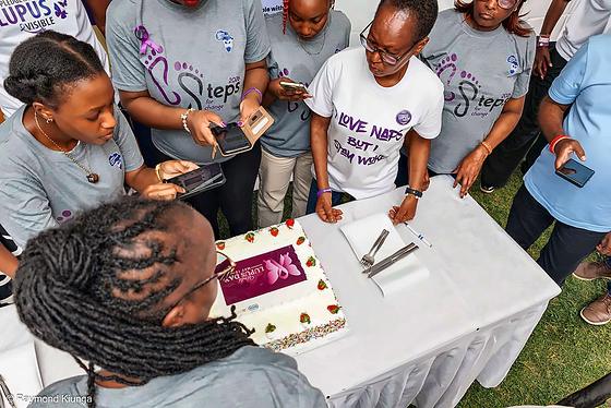 Phones held over the World Lupus Day cake