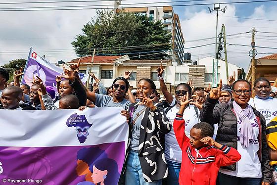 The LFA community raising their hands behind the Lupus Foundation of Africa banner on World Lupus Day 2026