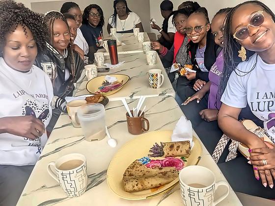 Sharing tea and chapati around a table during a KNH rheumatology ward visit