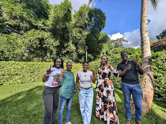 The LFA leadership team outdoors at a planning meeting, each making an L for lupus